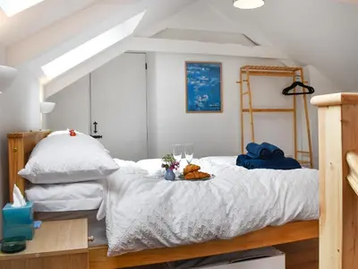 a bedroom with a bed with a tray of food on it at Roseland Retreat - Uk49838 in Truro