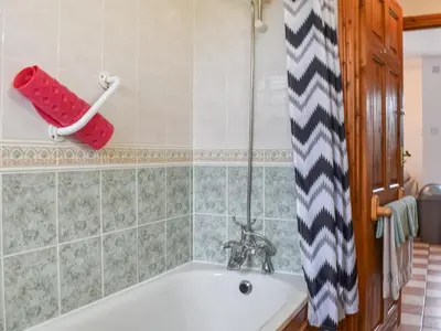 a bath tub in a bathroom with a red towel at Dairy Cottage - Uk49834 in Lanivet