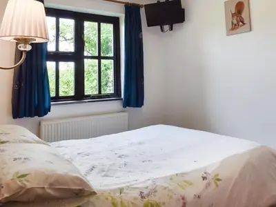 a bed sitting in a bedroom with a window at Dairy Cottage - Uk49834 in Lanivet