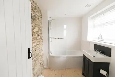 a bathroom with a shower and a sink and a tub at Parc Place in Gwithian