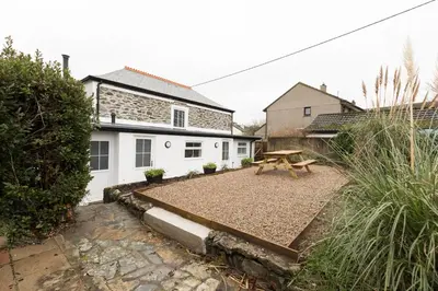a backyard with a picnic table and a house at Parc Place in Gwithian