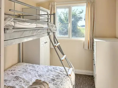 a bedroom with two bunk beds and a window at Seven Bays Retreat in Padstow