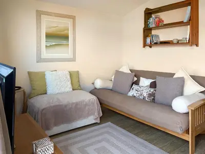 a living room with a couch and a tv at Seven Bays Retreat in Padstow