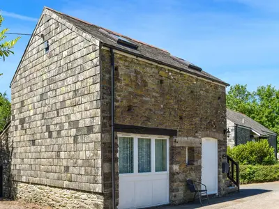 a brick house with a white garage at The Stable - Uk49829 in Callington