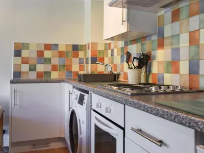a kitchen with a washing machine and a stove at The Stable - Uk49829 in Callington