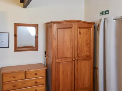 a wooden cabinet next to a dresser and a mirror at The Stable - Uk49829 in Callington