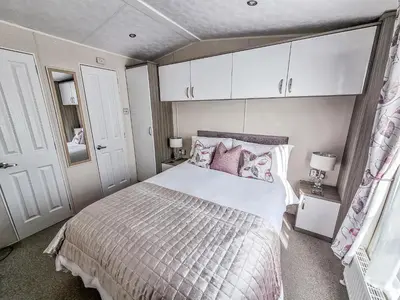a bedroom with a large bed with pink pillows at Serenity in Truro
