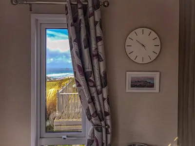 a clock on a wall next to a window at Serenity in Truro