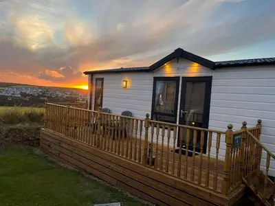 a tiny house with a wooden deck at sunset at Serenity in Truro
