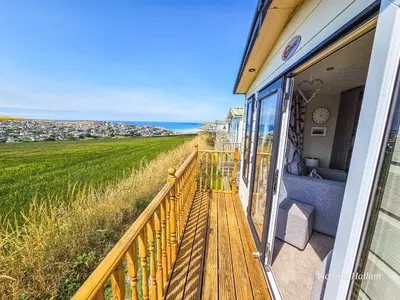 a balcony of a house with a wooden bench at Serenity in Truro