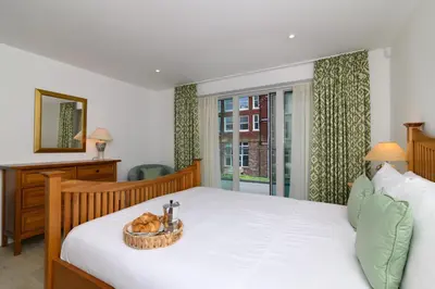 a bedroom with a bed with a basket of bread at Luxury Apartment very close to Tolcarne Beach in Newquay