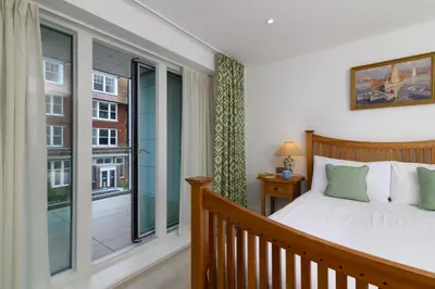 a bedroom with a bed and a balcony at Luxury Apartment very close to Tolcarne Beach in Newquay