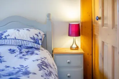a bedroom with a bed and a lamp on a night stand at 3 Bed in St. Endellion oc-o30761 in Saint Endellion