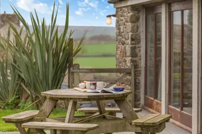 a picnic table with a cup of coffee on a patio at 3 Bed in St. Endellion oc-o30761 in Saint Endellion
