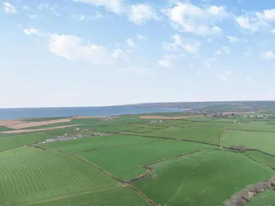 an aerial view of green fields and the ocean at 3 Bed in St. Endellion oc-o30761 in Saint Endellion