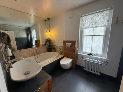 a bathroom with a tub and a sink and a toilet at Seaweed Suite, secluded seaside stay with garden view in Newquay