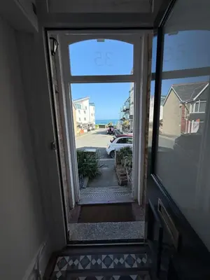 an open door to a hallway with a view of a street at Seaweed Suite, secluded seaside stay with garden view in Newquay
