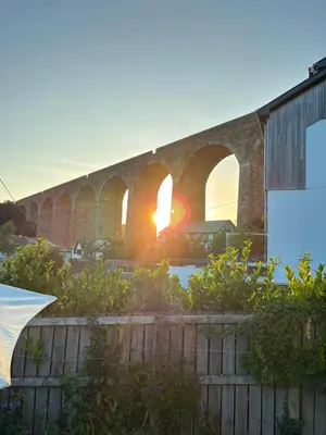 a brick bridge with the sun setting behind it at Back Lane Cottage Cornwall in Gwinear