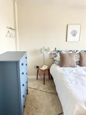 a bedroom with a blue dresser and a bed at North Coast Hideaway in Redruth