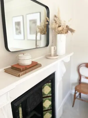 a fireplace in a living room with a mirror at North Coast Hideaway in Redruth