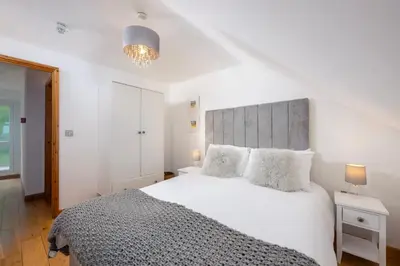 a bedroom with a large white bed with two pillows at Blue Mist Apartment in St Ives
