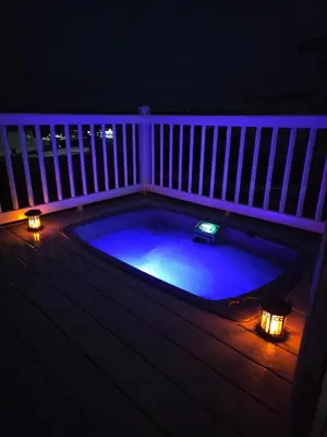 a hot tub on a deck at night with lights at Rural Retreat Chy Kensa a Hot Tub Haven in Grampound