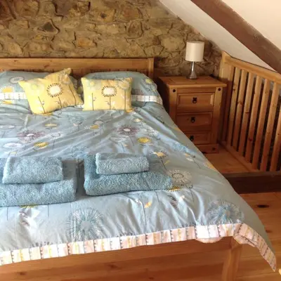 a bedroom with a bed with blue blankets and pillows at The Blacksmith's Shop in Port Isaac