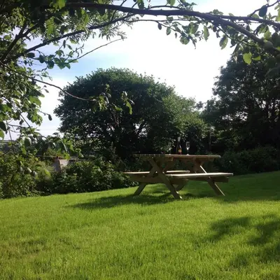 a picnic table sitting in the grass in a field at The Blacksmith's Shop in Port Isaac