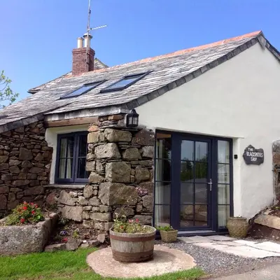 an old stone cottage with a window at The Blacksmith's Shop in Port Isaac