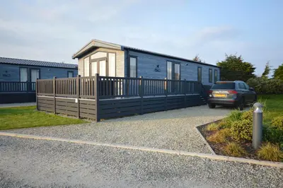 a car parked in front of a tiny house at Riverwood Lodge, Padstow in Padstow