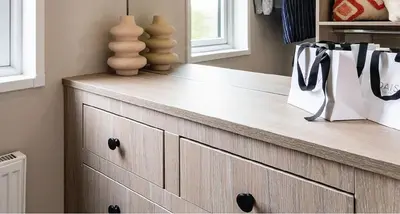 a wooden dresser in a living room with a lamp on it at Riverwood Lodge, Padstow in Padstow