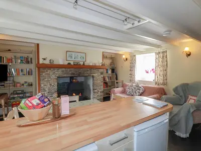 a living room with a table and a fireplace at Trevean in Bude