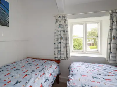 a bedroom with a bed and a window at Trevean in Bude