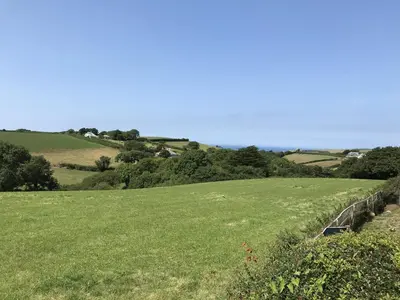 a large green field with a fence in the foreground at Trevean in Bude