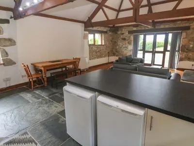 a kitchen and living room with a couch and a table at The Shippen in Penzance