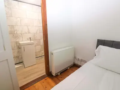 a small room with a bed and a radiator at The Shippen in Penzance