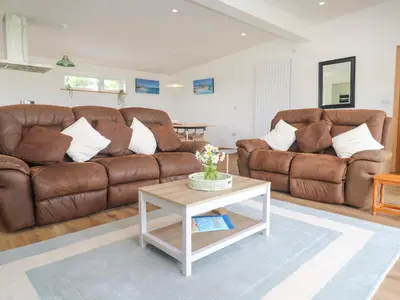 a living room with two brown couches and a coffee table at Swallows Nest in St Ives
