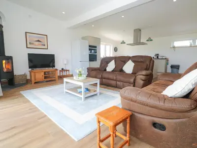 a living room with two brown leather couches and a tv at Swallows Nest in St Ives