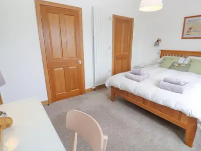 a bedroom with a bed and a table and chairs at Swallows Nest in St Ives