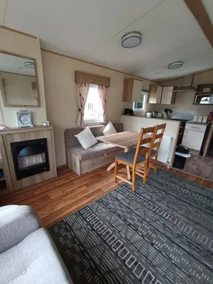 a living room with a table and a couch at The Green - Summer Breeze in Crantock