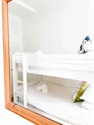 a mirror reflection of a bunk bed in a bedroom at Mermaid Apartment, A Colourful Coastal Escape By The Sea, Child Friendly in St Ives
