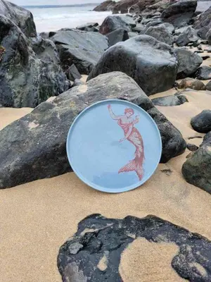 a plate with a drawing of a mermaid on the beach at Mermaid Apartment, A Colourful Coastal Escape By The Sea, Child Friendly in St Ives