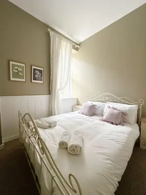 a bedroom with a white bed with towels on it at Lisas Beach Pad, A Charming Coastal Retreat with Parking in St Ives