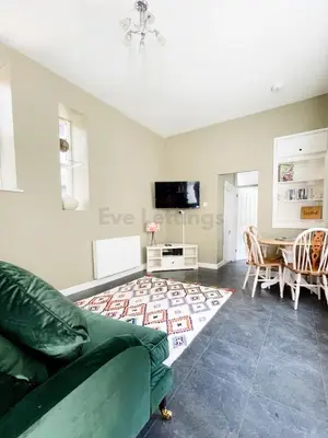 a living room with a couch and a table at Lisas Beach Pad, A Charming Coastal Retreat with Parking in St Ives