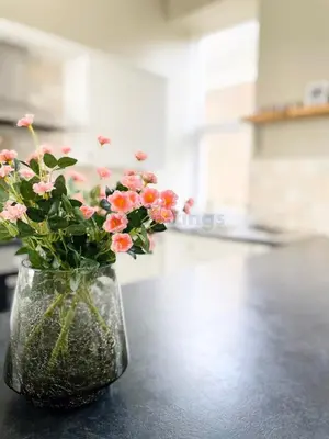 a vase filled with pink flowers sitting on a table at Lisas Beach Pad, A Charming Coastal Retreat with Parking in St Ives