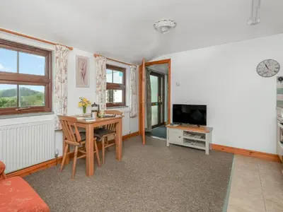 a living room with a table and a television at Hosta House - Uk49872 in Lanivet