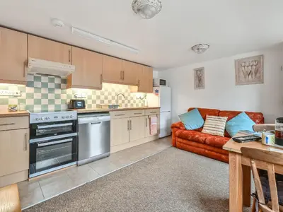 a living room with a couch and a kitchen at Hosta House - Uk49872 in Lanivet
