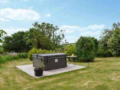 a small black shed with a table in a yard at Hosta House - Uk49872 in Lanivet