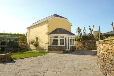 a house with a stone driveway in front of it at Tramways Holiday Cottage in Carnbrea