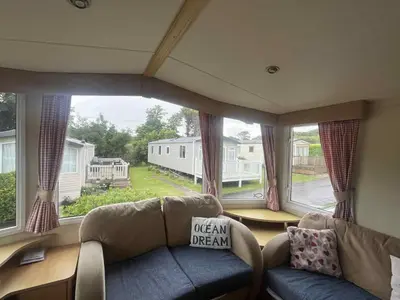 a living room with a couch and a large window at Pet Friendly Static in Carnbrea Station